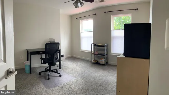 a view of a workspace with furniture and a window