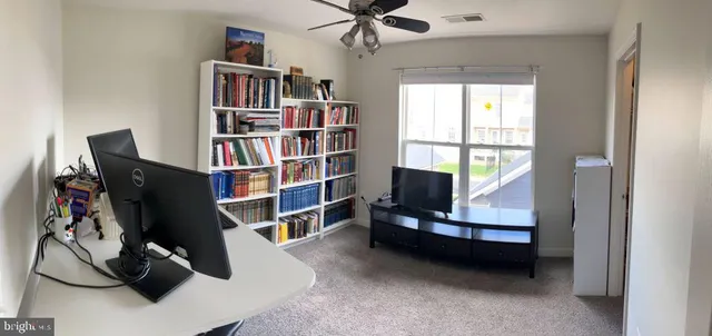 a living room with furniture a air conditioner and a book shelf