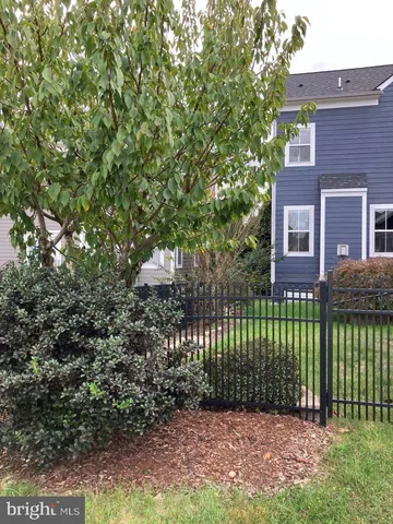 a view of a brick house with a yard and plants