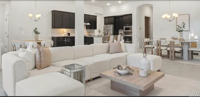 a living room with furniture and a view of kitchen