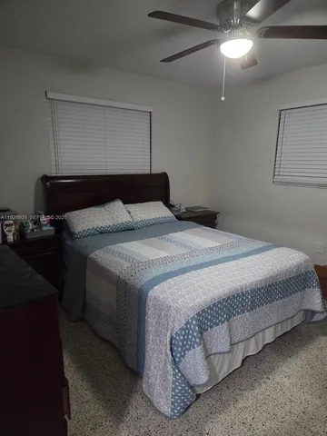 a bedroom with a bed and a ceiling fan