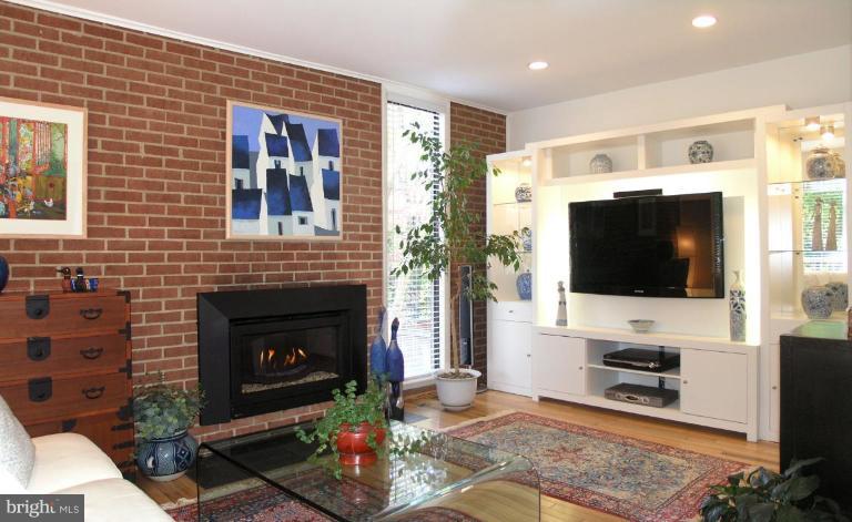 2023 Sarazen Place Reston, VA 20191 - Photo 21 of 30 a living room with furniture a flat screen tv and a fireplace
