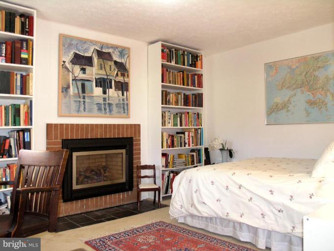 2023 Sarazen Place Reston, VA 20191 - Photo 10 of 30 a bedroom with a bed a book shelf and a book shelf