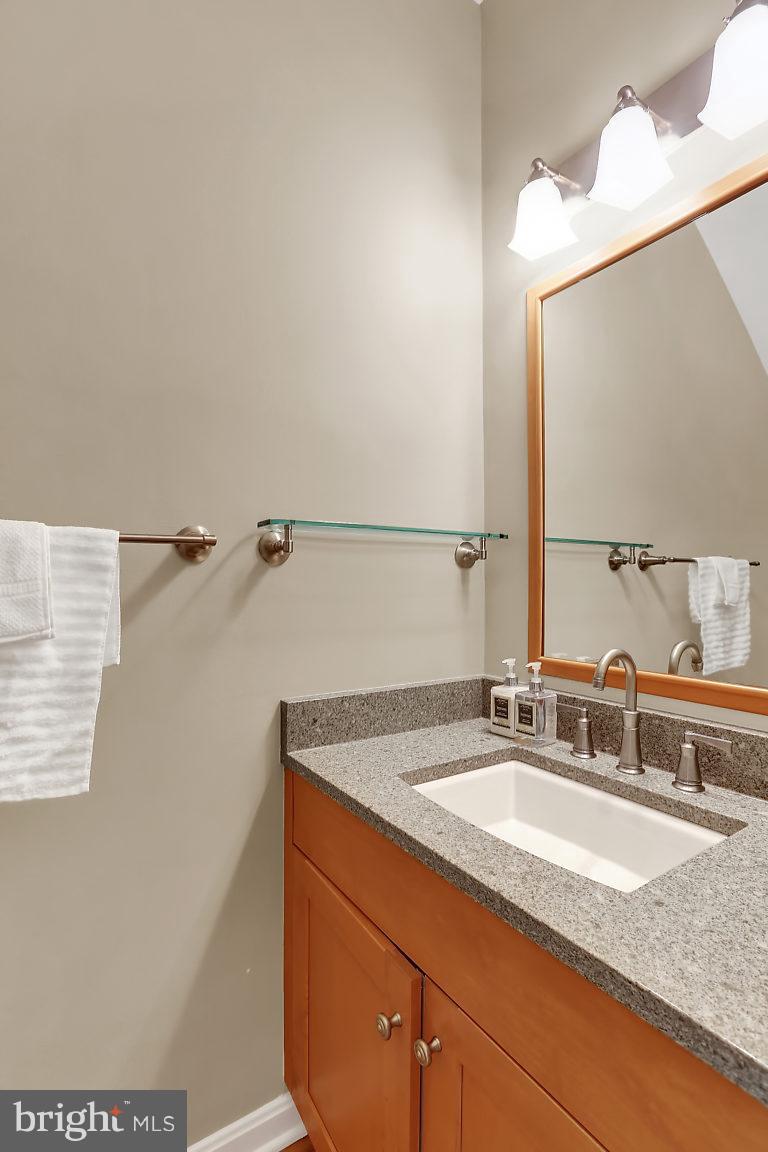 5711 Visitation Way Baltimore, MD 21210 - Photo 12 of 25 a bathroom with a granite countertop sink and a mirror
