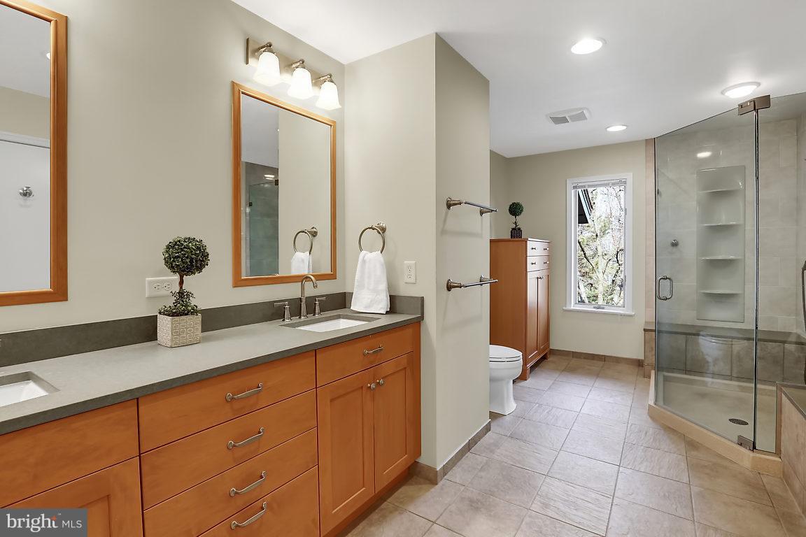 5711 Visitation Way Baltimore, MD 21210 - Photo 15 of 25 a spacious bathroom with a shower sink and mirror