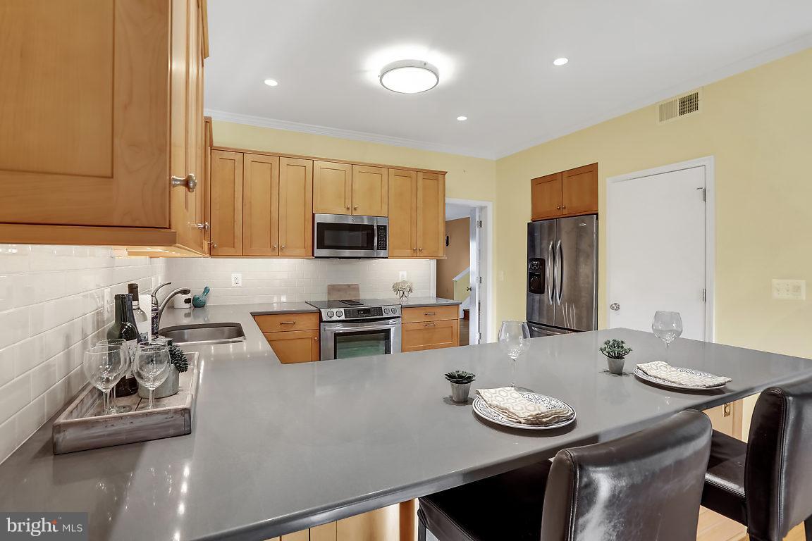 5711 Visitation Way Baltimore, MD 21210 - Photo 5 of 25 a kitchen with stainless steel appliances a dining table and chairs