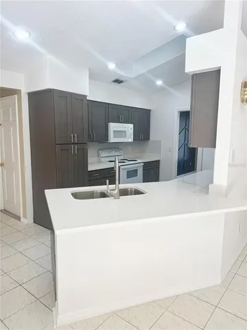 a large kitchen with kitchen island a sink a stove a refrigerator and a cabinets