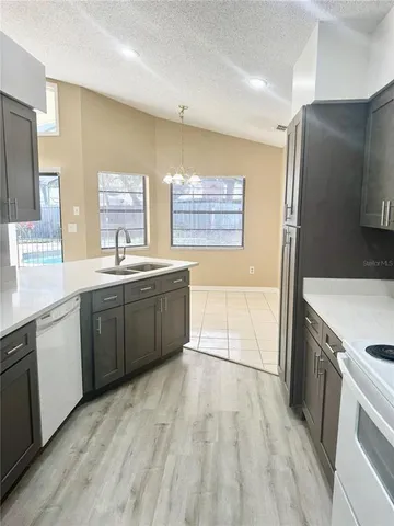 a kitchen with stainless steel appliances a sink cabinets and wooden floor