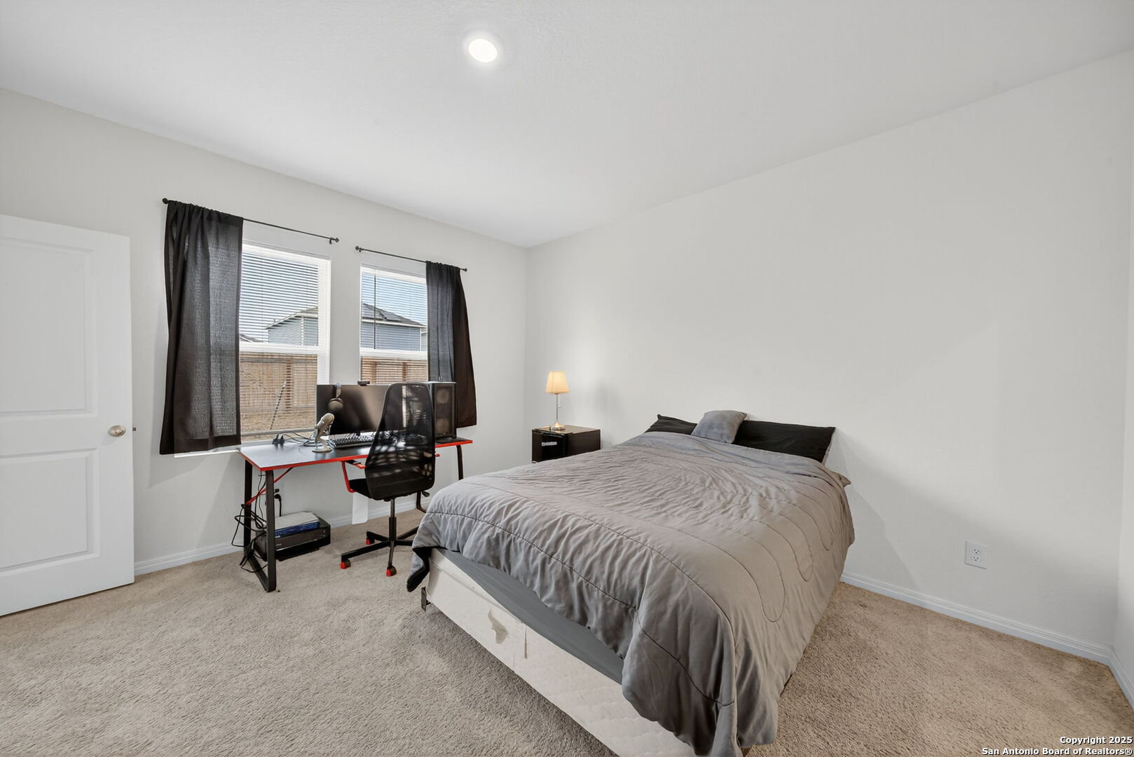 7710 Fern Hollow San Antonio, TX 78252 - Photo 12 of 26 a bedroom with a bed and a large window