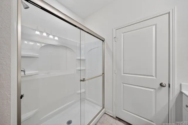 a bathroom with a glass shower door and a shower