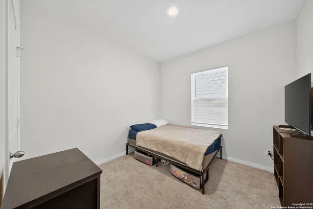 a bedroom with a bed and a flat tv screen on a dresser