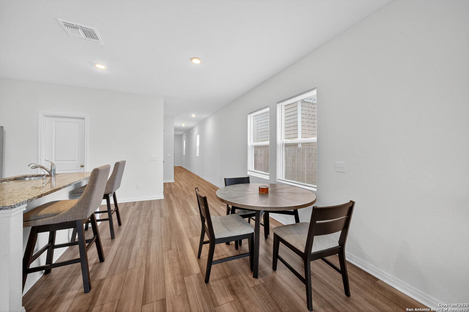 7710 Fern Hollow San Antonio, TX 78252 - Photo 6 of 26 a view of a dining room with furniture and wooden floor