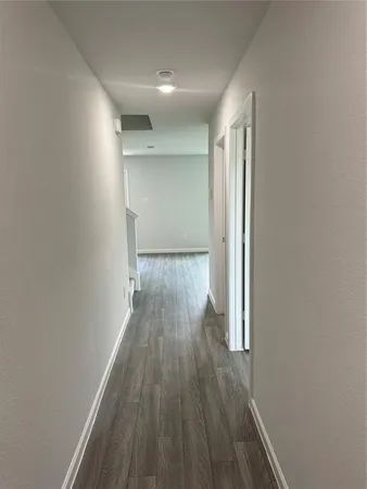 a view of a room with wooden floor and a window