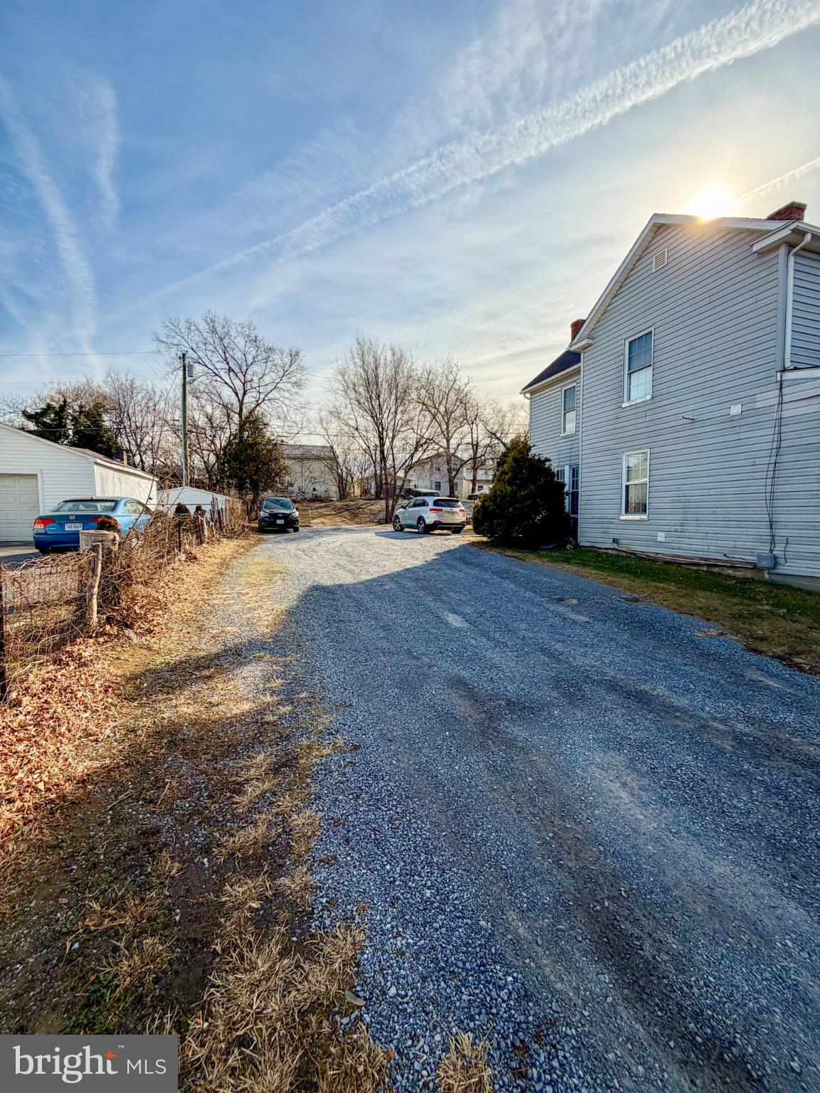 24 North Pleasant Valley Road Winchester, VA 22601 - Photo 3 of 11 Charming gravel drive under a sunny sky.