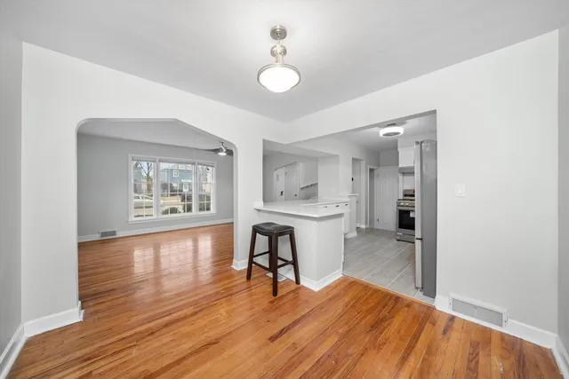 a view of a workspace with wooden floor and a window