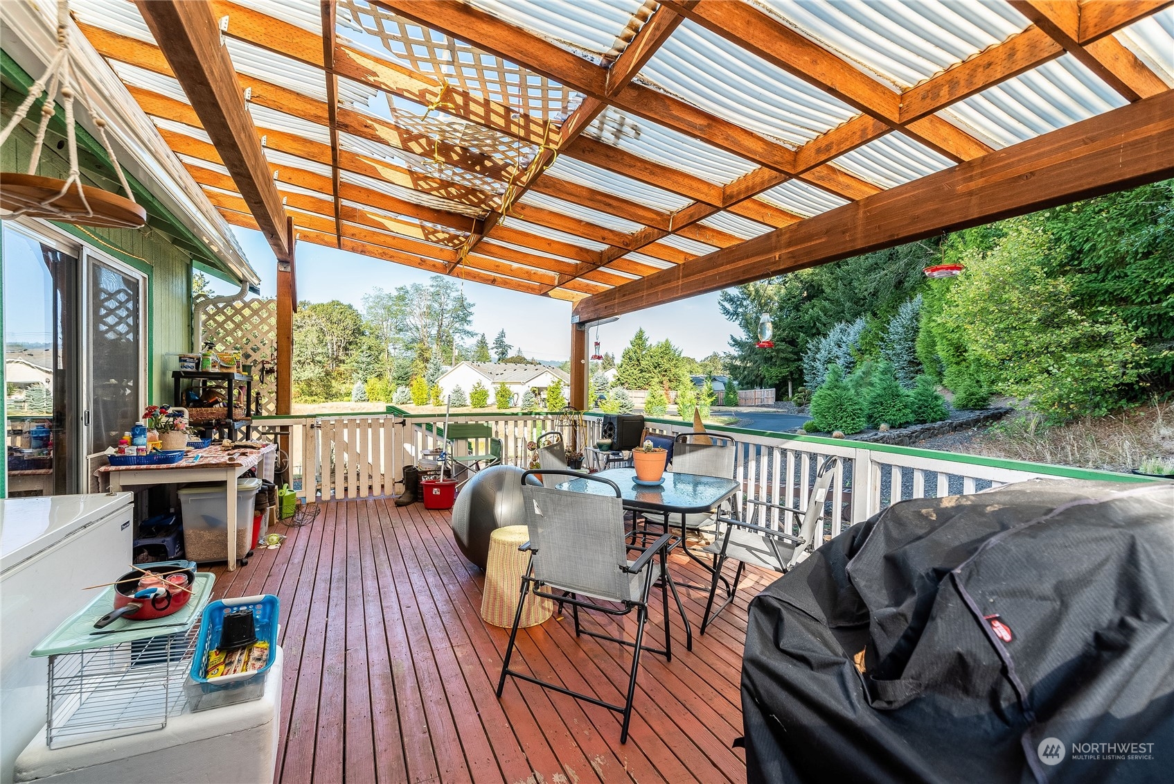 10136 Meadowside Lane Southwest Rochester, WA 98579 - Photo 23 of 32 a view of porch with furniture and trees