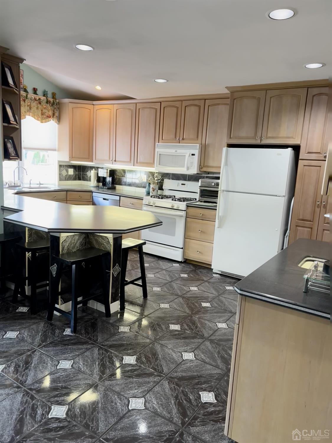 3 Barton Road Old Bridge, NJ 08857 - Photo 11 of 38 a kitchen with kitchen island granite countertop wooden cabinets a sink a stove and a refrigerator