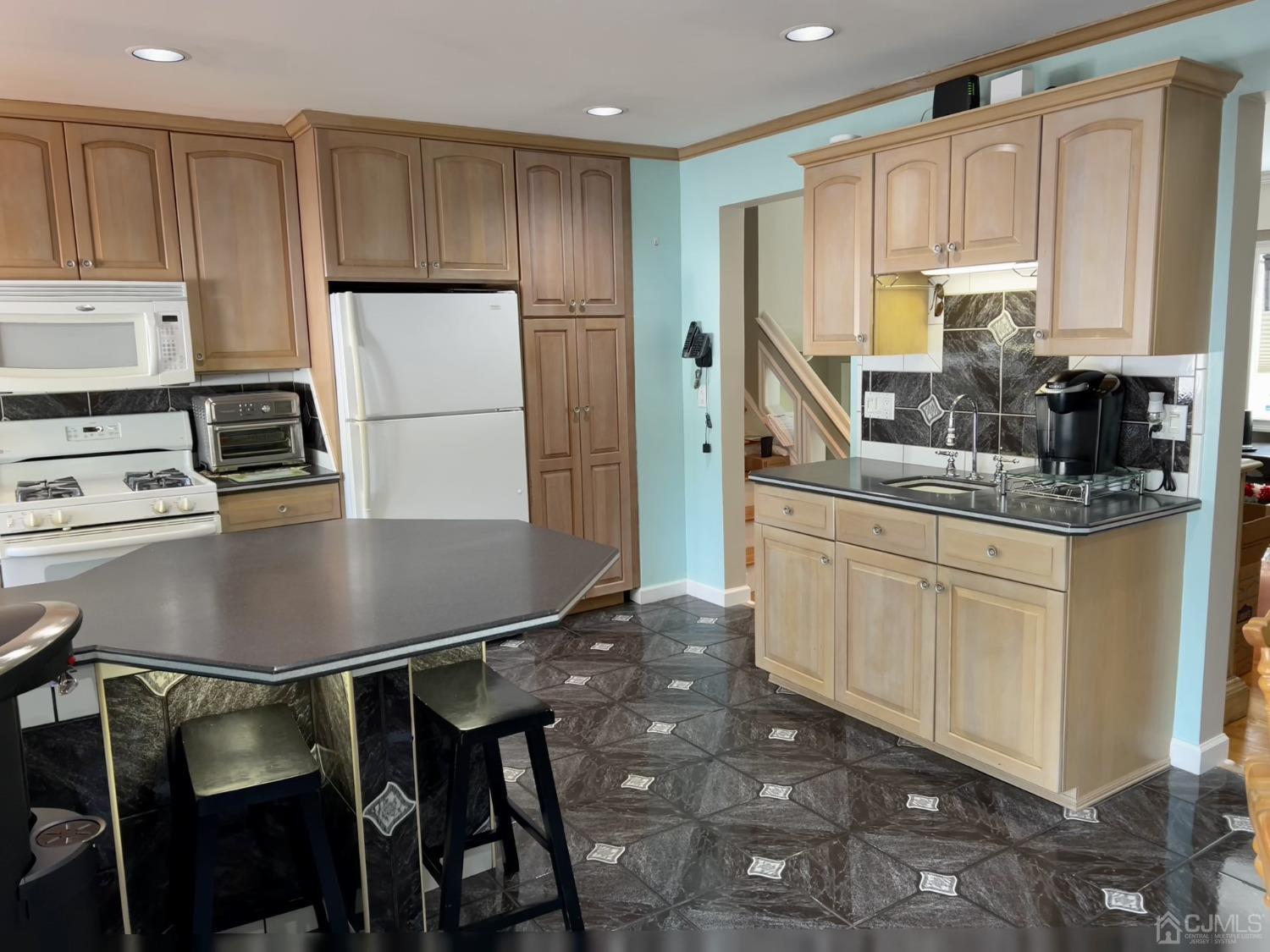 3 Barton Road Old Bridge, NJ 08857 - Photo 14 of 38 a kitchen with kitchen island a stove a sink refrigerator and white cabinets with wooden floor