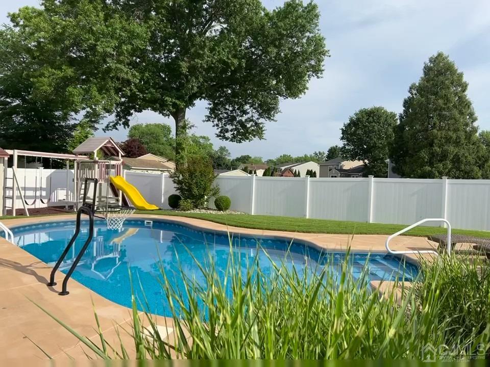 3 Barton Road Old Bridge, NJ 08857 - Photo 3 of 38 a view of a swimming pool with a bench and wooden fence