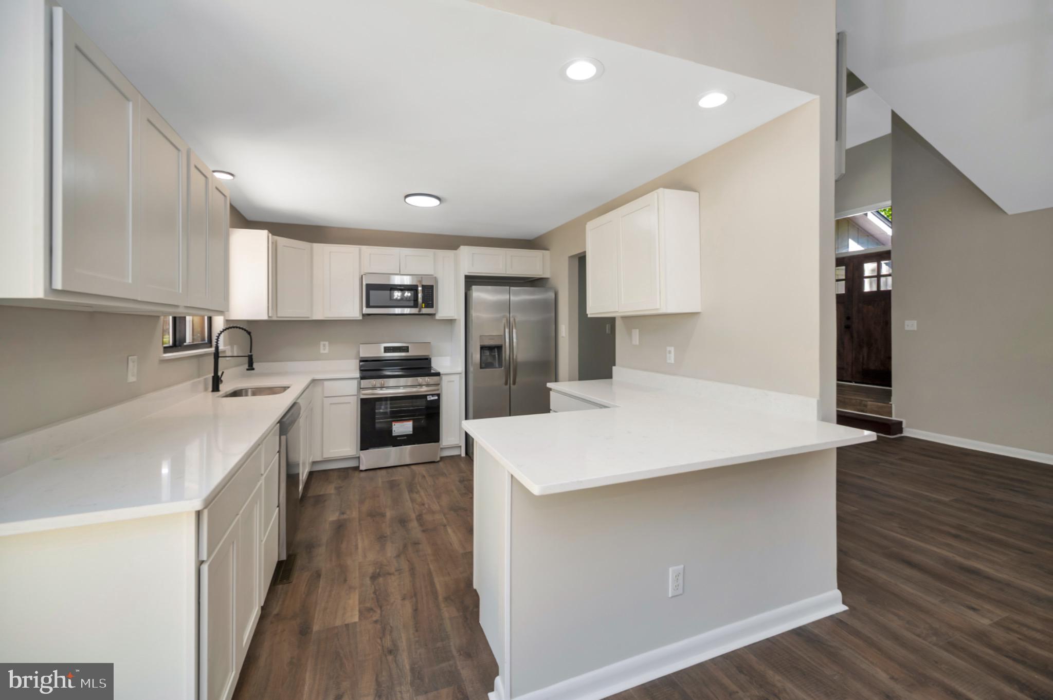 420 Birdie Road Locust Grove, VA 22508 - Photo 7 of 53 a kitchen with stainless steel appliances a refrigerator sink and wooden cabinets