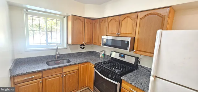 a kitchen with stainless steel appliances granite countertop a sink stove and microwave