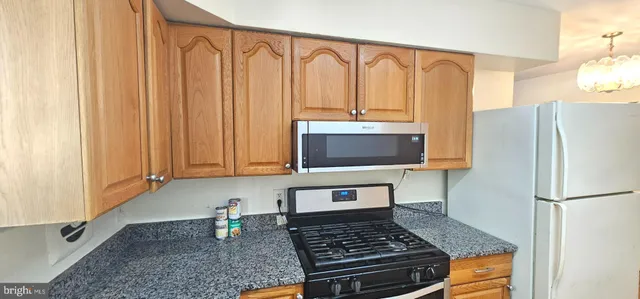 a kitchen with stainless steel appliances granite countertop a refrigerator stove and microwave
