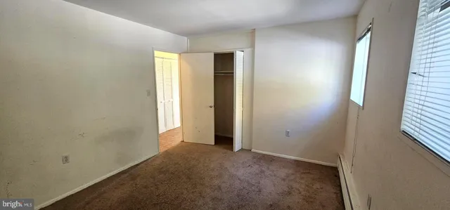 an empty room with windows and closet