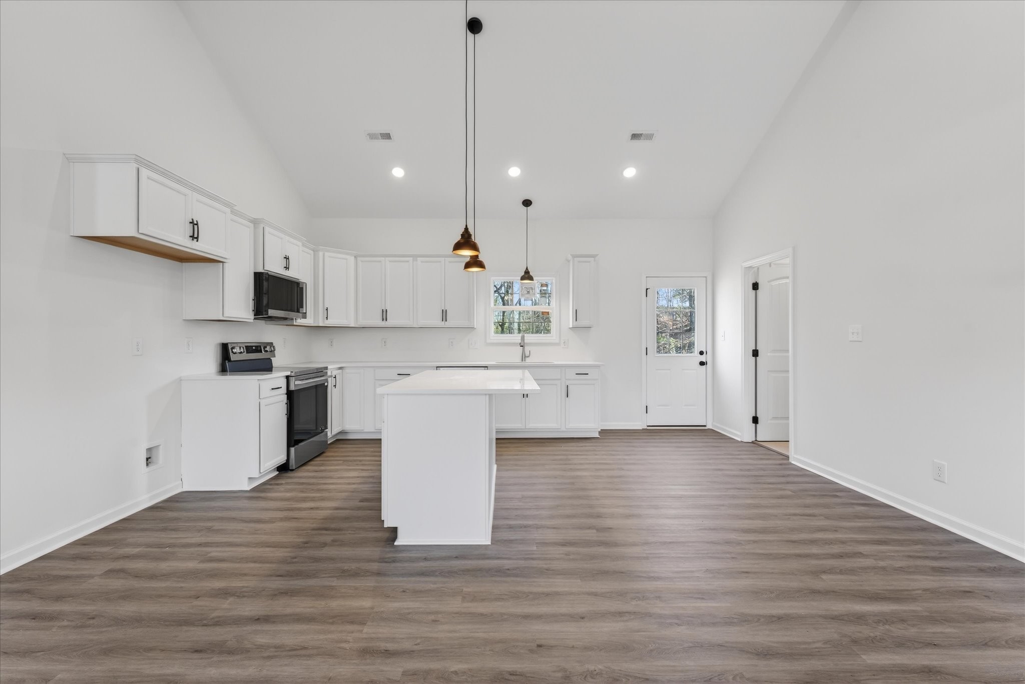 613 Hill Road Clarksville, TN 37040 - Photo 12 of 37 a large kitchen with white cabinets a sink dishwasher a refrigerator and a stove with wooden floor