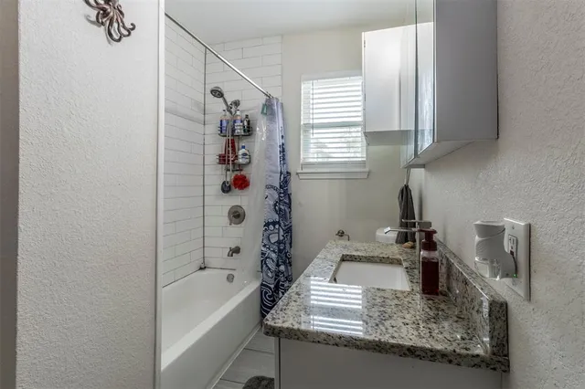 a bathroom with a tub sink and mirror