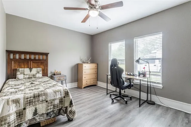 a bedroom with a bed a chair and a large window