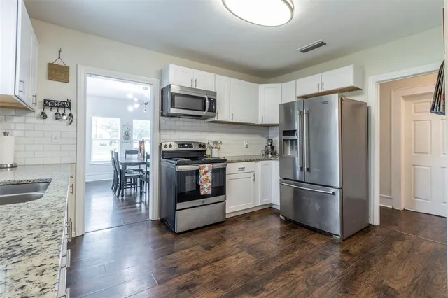 a kitchen with stainless steel appliances a refrigerator stove and microwave