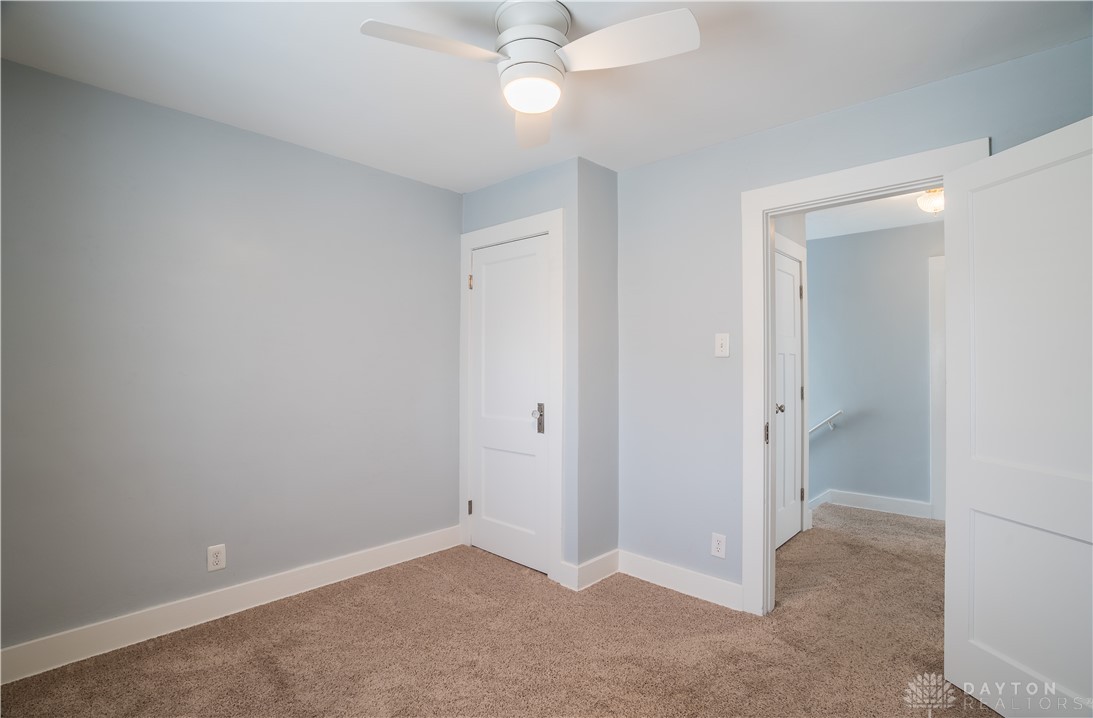 303 South Ridge Avenue Troy, OH 45373 - Photo 18 of 37 This inviting space features comfortable carpeting and a ceiling fan, creating an ideal setting for relaxation.