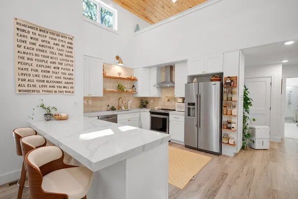 a kitchen with a refrigerator a stove cabinets and wooden floor