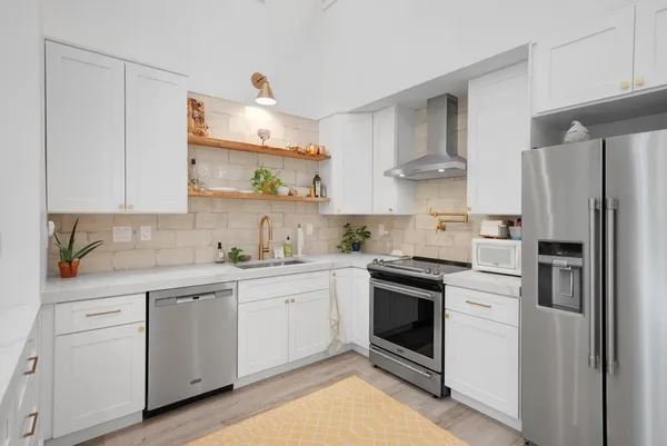 a kitchen with white cabinets and white appliances