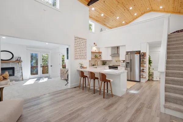 a large open kitchen with a table chairs refrigerator and cabinets