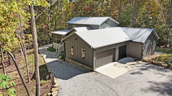 a view of a house with a yard and large tree