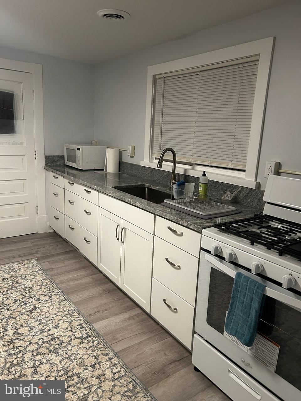 89 Second Street Keyser, WV 26726 - Photo 2 of 37 a kitchen with granite countertop white cabinets and white appliances