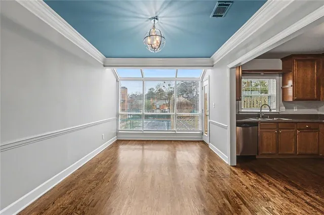 an empty room with wooden floor and a bathroom