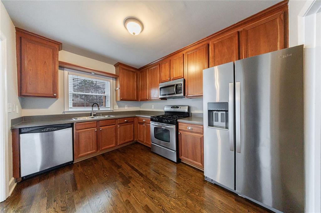 125 Mt Vernon Circle Atlanta, GA 30338 - Photo 17 of 62 a kitchen with granite countertop wooden floors stainless steel appliances and a window