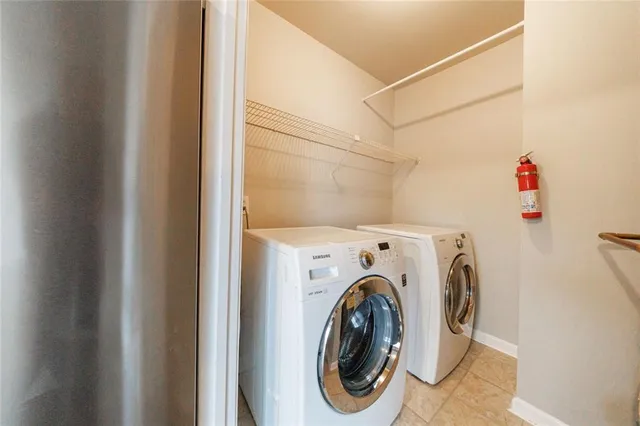 a spacious bedroom with a bed a couch and windows