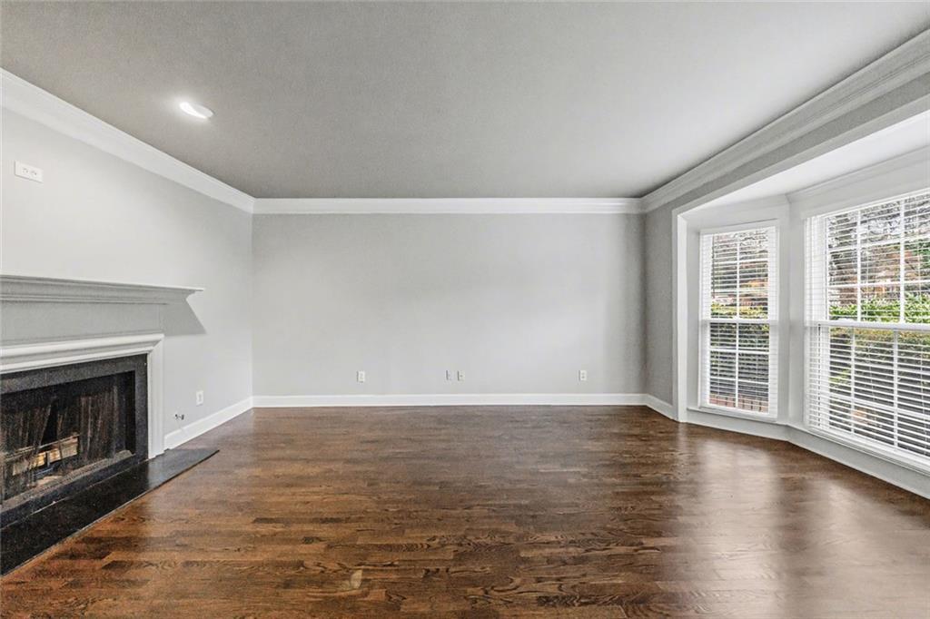 125 Mt Vernon Circle Atlanta, GA 30338 - Photo 49 of 62 an empty room with wooden floor fireplace and windows