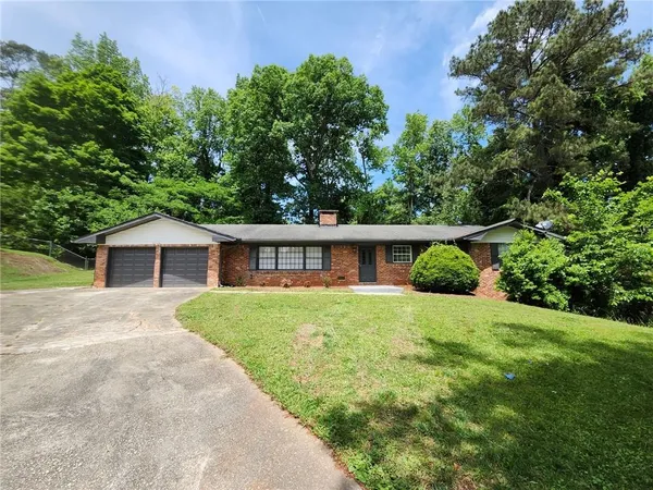 a front view of a house with a yard and trees