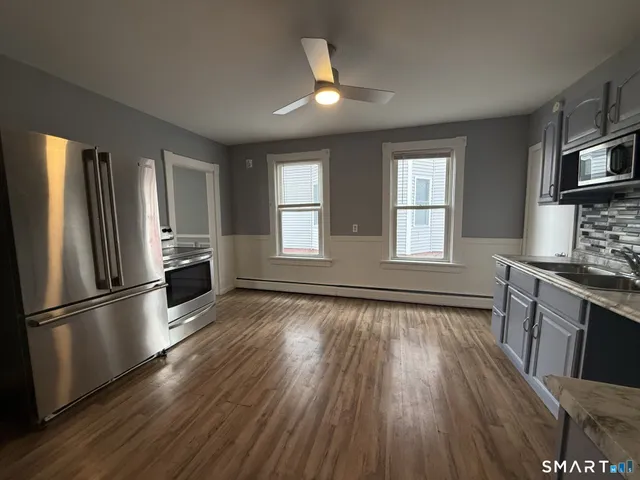 a kitchen with granite countertop wooden floors and stainless steel appliances