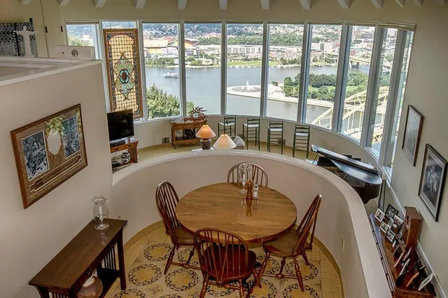 a dining room with furniture and a floor to ceiling window
