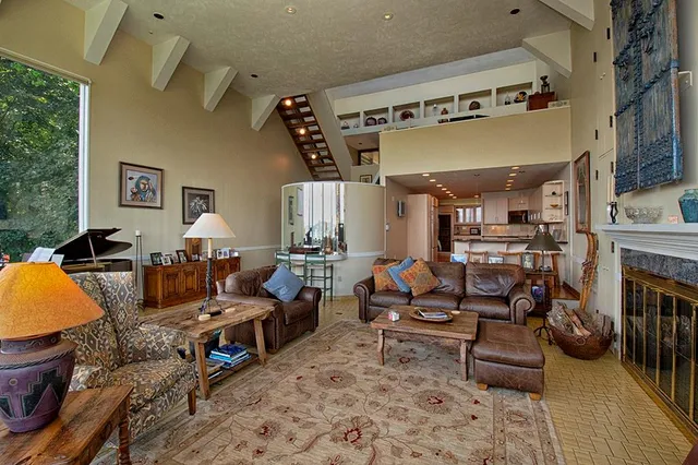a living room with furniture fireplace and a large window