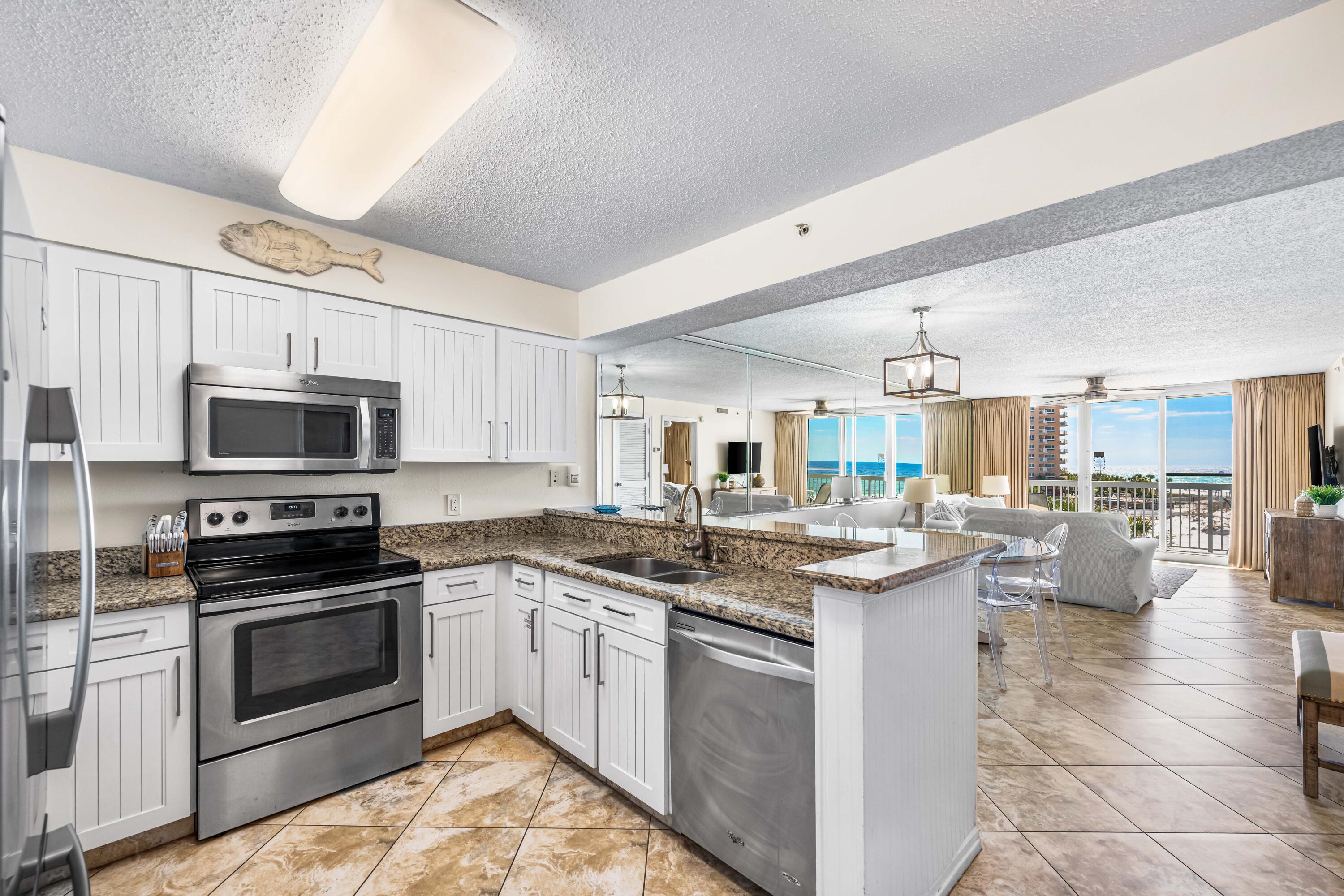 1002 Highway 98, Unit 415 Destin, FL 32541 - Photo 1 of 31 a kitchen with stainless steel appliances granite countertop a stove top oven a sink dishwasher a dining table and chairs with wooden floor