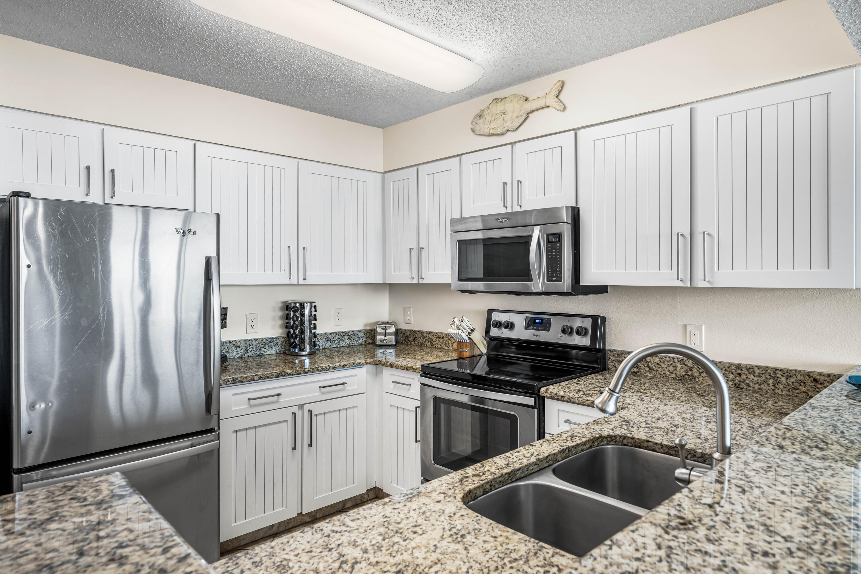 1002 Highway 98, Unit 415 Destin, FL 32541 - Photo 4 of 31 a kitchen with stainless steel appliances granite countertop a sink a stove a refrigerator and cabinets