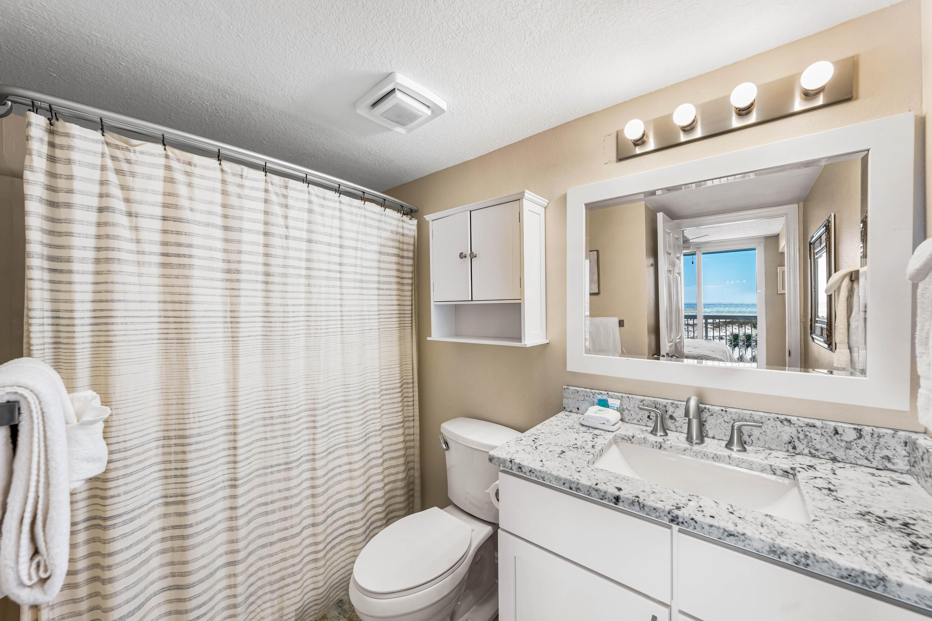 1002 Highway 98, Unit 415 Destin, FL 32541 - Photo 9 of 31 a bathroom with a granite countertop sink vanity mirror and toilet