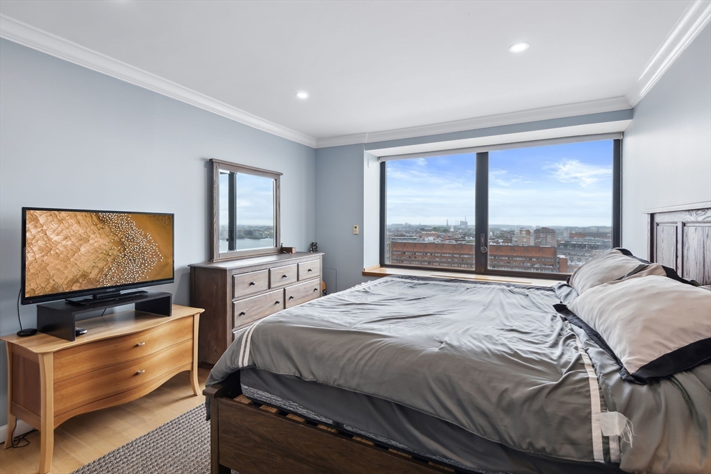 85 East India Row, Unit 16H Boston, MA 02110 - Photo 11 of 20 a bedroom with a bed and large windows