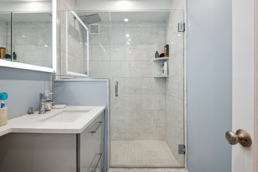 85 East India Row, Unit 16H Boston, MA 02110 - Photo 15 of 20 a bathroom with a sink and mirror